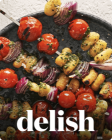 La copertina di Delish con un’immagine di shish kebab alla griglia su un piatto.